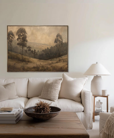 Living room with a beige sofa, wooden coffee table, and landscape painting on the wall.