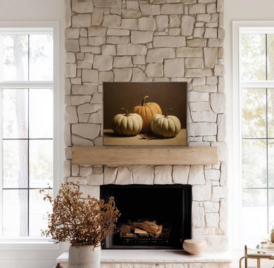 Stone fireplace with a mantel displaying pumpkins, flanked by windows.