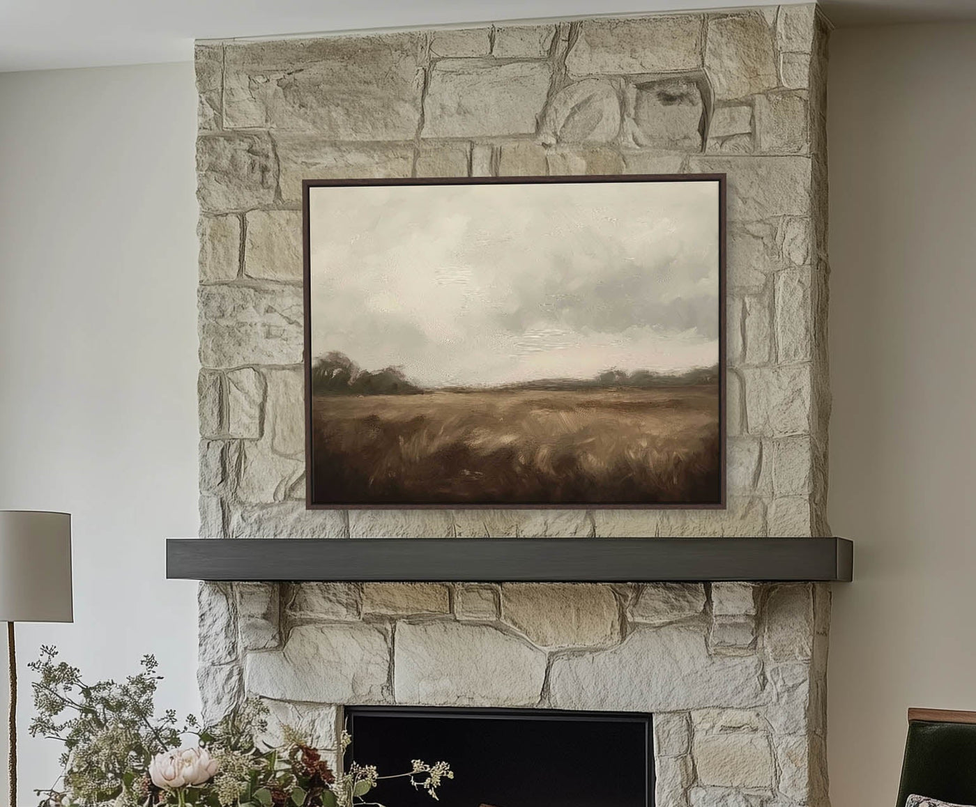 Stone fireplace with a painting above it in a living room setting.