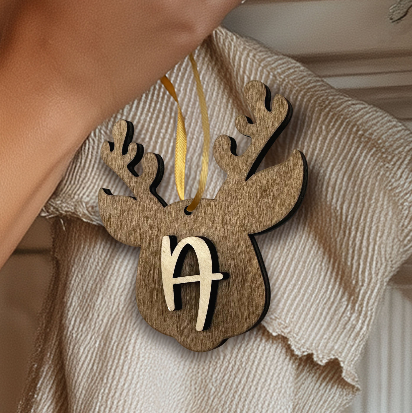 "Personalized wooden reindeer stocking tag with custom initial, hanging on a Christmas stocking with ribbon."