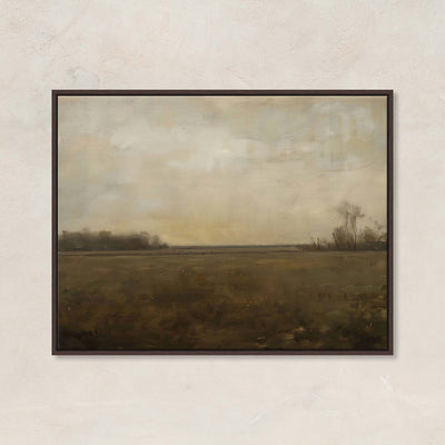 Framed landscape painting of a field with a cloudy sky on a beige wall.